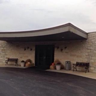 A building entrance with stone walls and benches on either side.
