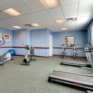 A small fitness room with exercise equipment including treadmills and stationary bikes.