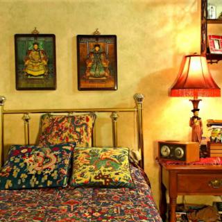 A cozy bedroom with colorful bedding and warm lighting.