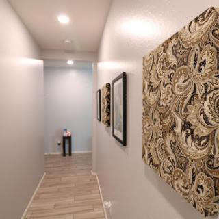 A well-lit and elegantly decorated hallway featuring patterned wall art.