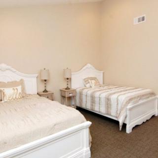 A cozy bedroom with two twin beds and matching nightstands.