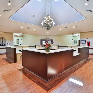 Modern reception area with a central desk and chandelier.