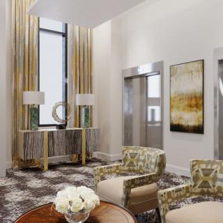 A modern and elegantly designed lobby featuring stylish furniture, beautiful artwork, and elevators.