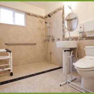 A modern, wheelchair-accessible bathroom with grab bars, a shower area, and a toilet.