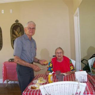 Two elderly men enjoying a meal together in a cozy dining setting.
