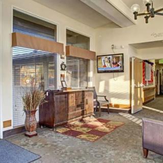 A cozy lobby area with a wooden cabinet, decorative items, and seating.