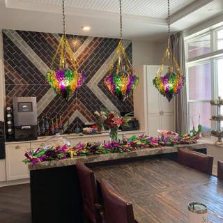 A modern kitchen with colorful pendant lights and elegant flower arrangements.