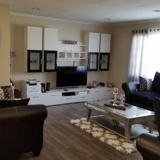 A modern living room with a flat-screen TV, cozy sofas, and a stylish coffee table.