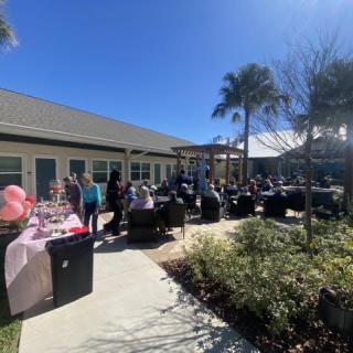 A sunny outdoor gathering with people enjoying the event under clear skies.