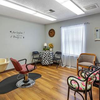 A cozy and well-lit hair salon interior with stylish decor and seating.