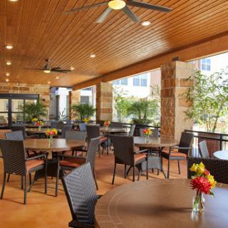 A spacious indoor dining area featuring stylish tables, comfortable seating, and vibrant floral arrangements.