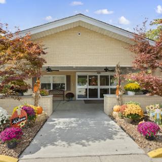 A beautiful entrance to a welcoming residence, adorned with vibrant flowers and lush landscaping.