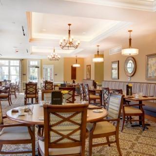 A well-decorated dining area with elegant chandeliers and neatly arranged tables and chairs.