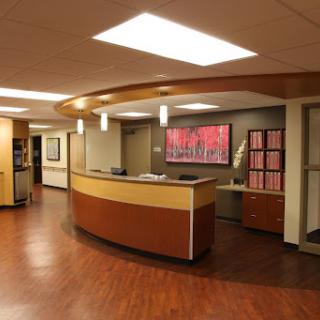 A modern medical reception area featuring a curved desk and contemporary decor.