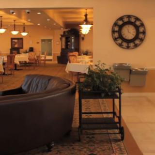 A cozy lobby area featuring a sofa, clock, and warm lighting.