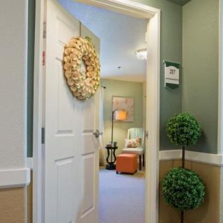 A warmly decorated interior space viewed through an open door, featuring cozy furnishings and decorative elements.