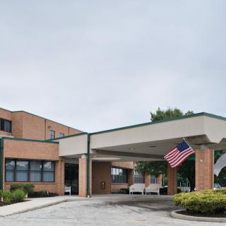 A brick building with an entrance canopy and an American flag.