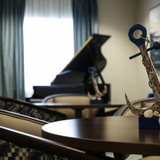 A cozy interior with a grand piano and saxophone sculptures on tables.