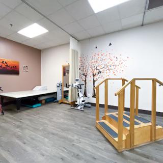A spacious physical therapy room equipped with exercise facilities and a welcoming atmosphere.