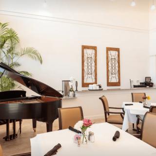 Elegant restaurant dining area featuring a grand piano and white tablecloths.
