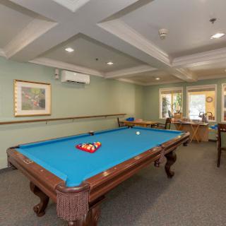 A well-lit recreation room featuring a blue pool table, inviting for friendly games.