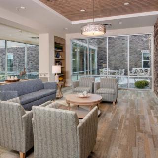 A modern living room with ample seating and large windows providing plenty of natural light.