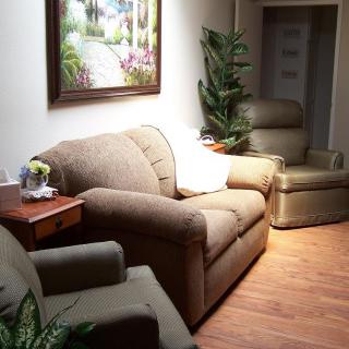 A cozy living room with comfortable seating and a painting on the wall.