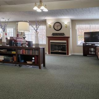 A cozy living room featuring a fireplace, television, and bookshelves.
