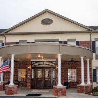 An entrance to a building featuring columns and an American flag.