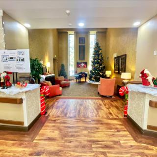 A beautifully decorated lobby featuring a Christmas tree and festive decor, creating a warm and inviting atmosphere.