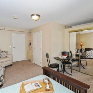 A cozy living space featuring a dining area with a mirrored wall, comfortable seating, and homey decor.