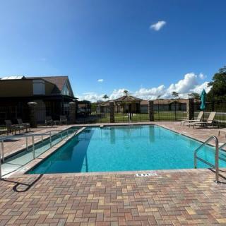 A sunny day by the outdoor swimming pool, surrounded by a patio with lounge chairs.