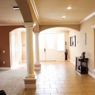 A spacious and welcoming entrance hall featuring elegant columns and abundant natural light.