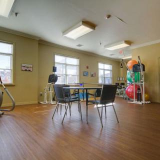 A spacious gym room with exercise equipment and a seating area.