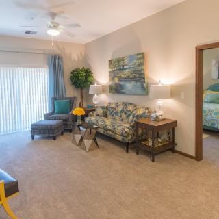 A cozy living room featuring a patterned sofa, wall art, and soft lighting.