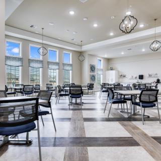 A spacious and modern dining area with contemporary furniture and large windows providing ample natural light.