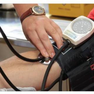 A healthcare professional measuring blood pressure using a sphygmomanometer.