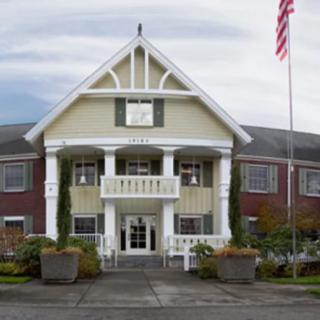 A two-story building with an American flag and landscaped entrance.