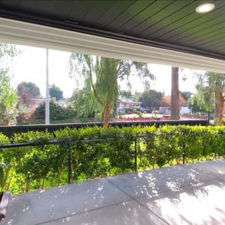 A sunny patio with a view of lush greenery and a garden.