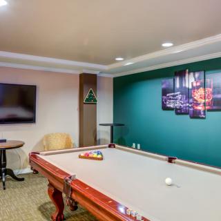 A modern game room featuring a pool table, television, and stylish decor.