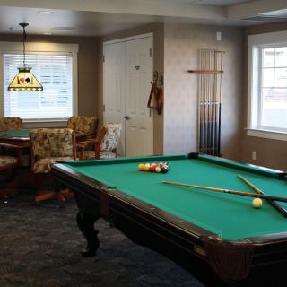 A cozy game room featuring a pool table and seating area.