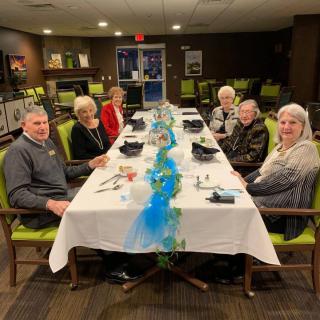 A group of people enjoying a meal together at a decorated table.