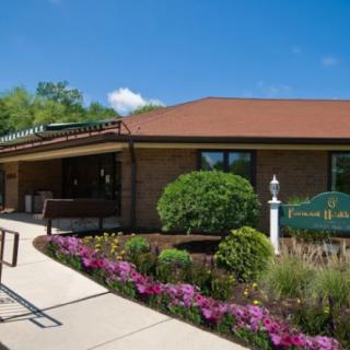 A library building surrounded by lush greenery and vibrant flowers.