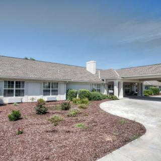 A suburban home with well-maintained landscaping and a curved driveway.