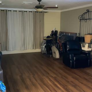 A spacious living room with hardwood floors and a recliner.