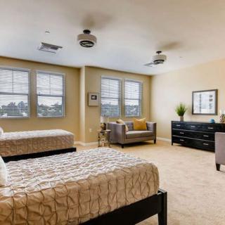 A spacious bedroom with twin beds and a cozy seating area.