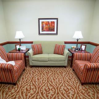 A cozy living room with a sofa, matching armchairs, and warm lighting.