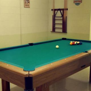 A pool table set up in a recreation room, ready for a game of billiards.