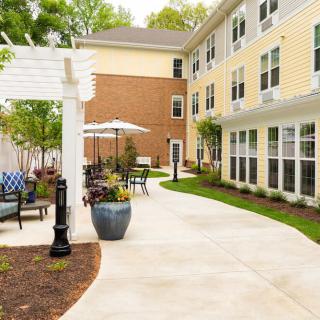 A well-maintained outdoor patio area with seating next to a multi-story building.