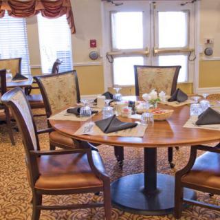 A neatly set dining table in a well-decorated interior, ready for guests.